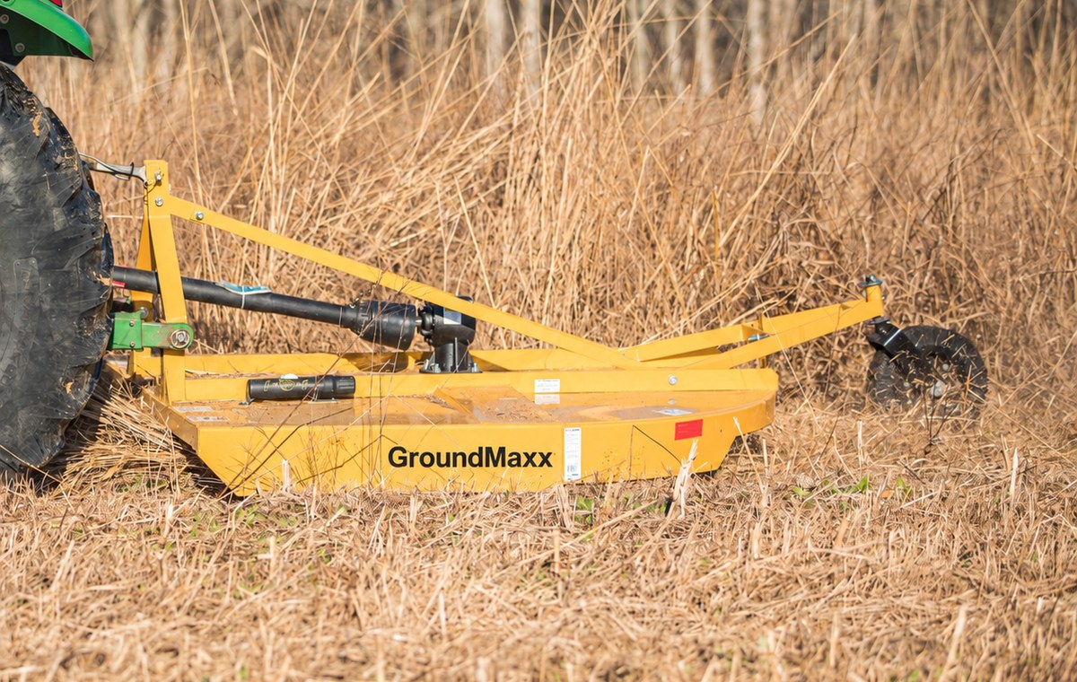 GroundMaxx RC72 rotary cutter mounted on a tractor, cutting through tall dormant grass and brush